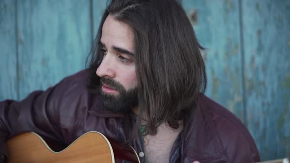 Male Artist Practicing His Singing and Guitar Playing Outdoors