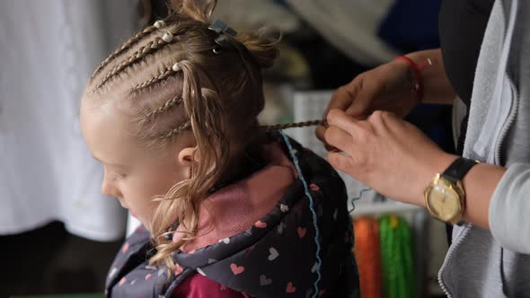 Closeup of Female Braiding Hair of Little Girl