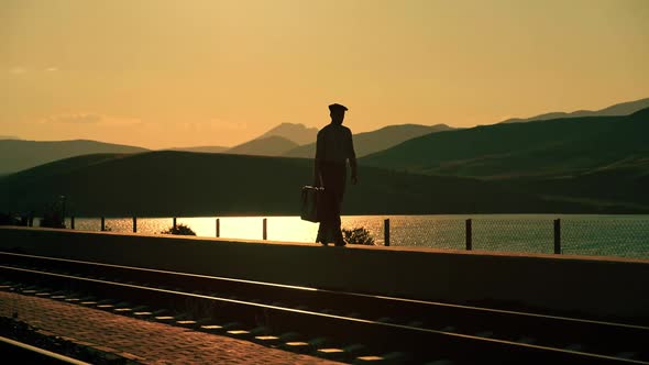 Man Walking on a Railway Station at Sunset