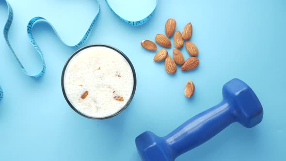 Almond Nut Dumbbell and Milk on Blue