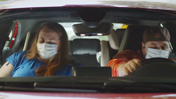 Overweight Young Couple with Disposable Masks Getting in Car