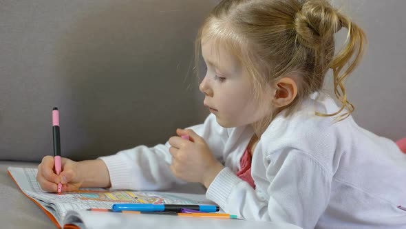 Preschool Female Drawing With Markers in Coloring Book