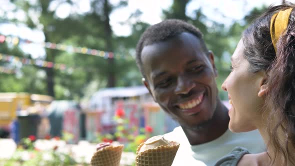 Man and Woman Enjoy Eating Ice Cream and Talking in Park