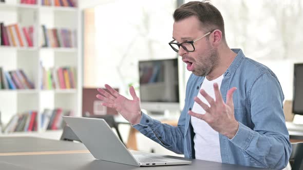 Young Man Upset By Loss, Using Laptop