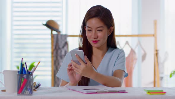 beautiful asian woman using smart phone or mobile phone at home
