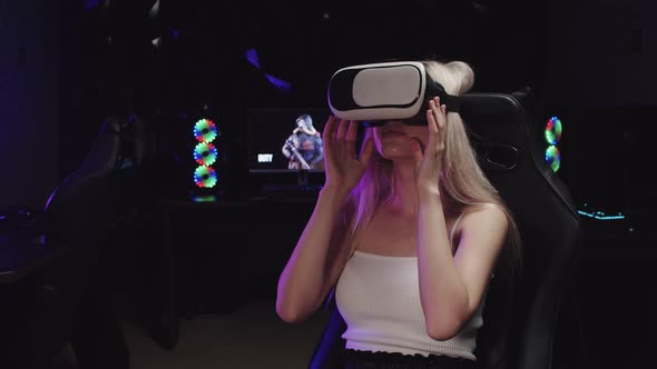 Young Blonde Sexy Gamer Girl Sitting in VR Glasses