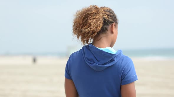 Close-up of a black woman beach volleyball player letting her hair down.