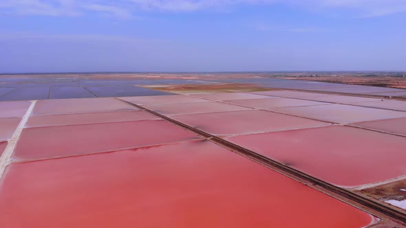 Epic Aerial View of Colorful Pink Salt Lake and Clouds Reflection on Calm Water Surface