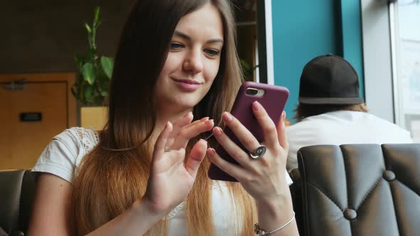 Portrait of Young Woman Use Mobile Phone in Cafe