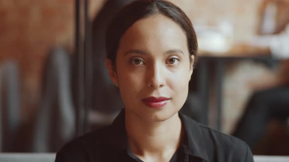 Happy Mixed Raced Woman Smiling and Posing for Camera in Cafe