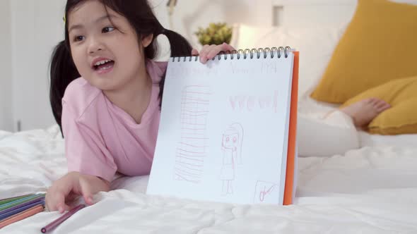 Asia japanese woman child kid relax rest fun happy draw cartoon in sketchbook.