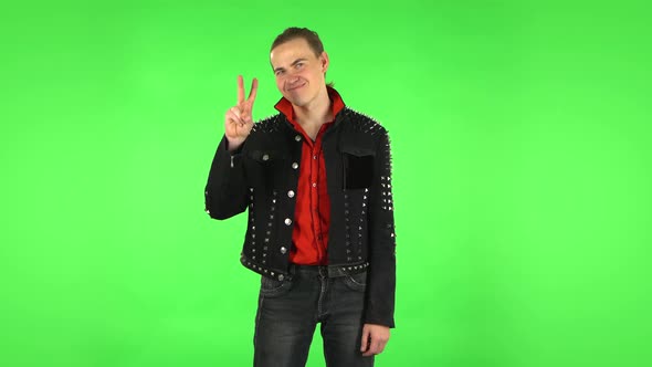 Guy Shows Two Fingers Victory Gesture. Green Screen