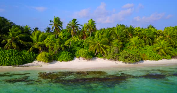 Tropical drone travel shot of a white paradise beach and aqua blue water background in 4K