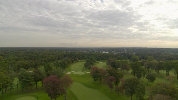 Aerial Tilt Down Shot of a Golf Course with Colorful Autumn Trees