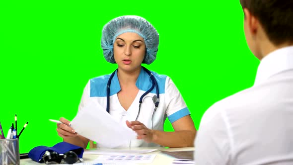 Doctor Sitting at the Table Explains Diagnosis of a Young Woman