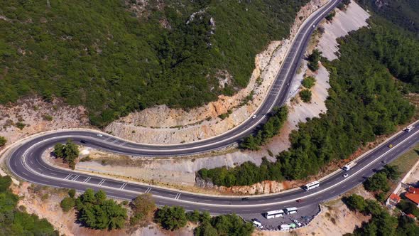 Cars Traffic on Curvy Serpentine Road Snaking Between Mountains