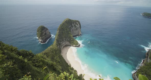 Pull Back Shot of Stunning Tropical Beach with Blue Sea and Rocky Peninsula From Above Kelingking