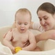 Happy Smiling Mother Looking at Her Little Baby Son Splashing Water and Playing in Bath - VideoHive Item for Sale