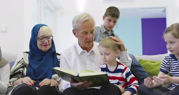 Muslim Family Generations Grandparents Reading Quran with Grandchildren at Home