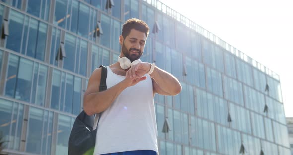 Young Athletic Man with Fitness Tracker on City Street