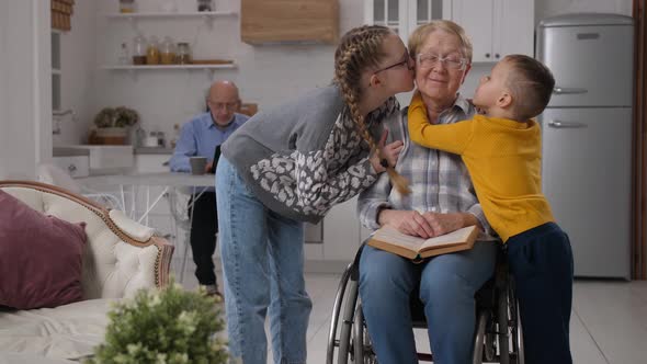 Loving Grandchildren Kissing Disabled Grandmother