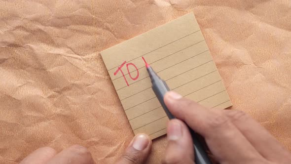 Writing a to Do List on a Sticky Note