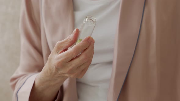 Woman's Hand is Holding a Medicine in Closeup an Elderly Woman is Holding a Pill in Her Hands