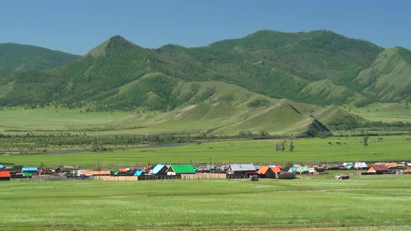 Colorful Houses of a Russian Town in Forest and Meadow By River in Siberia, Russia