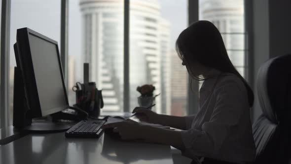 Young Woman Works in an Office with Documents