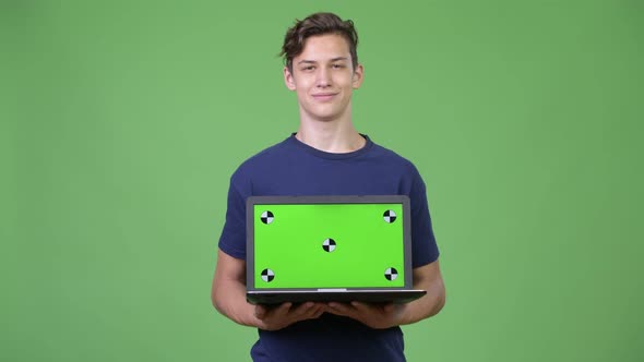 Young Handsome Teenage Boy Showing Laptop