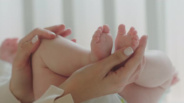 Young Mother s Hands Carefully Holding the Baby