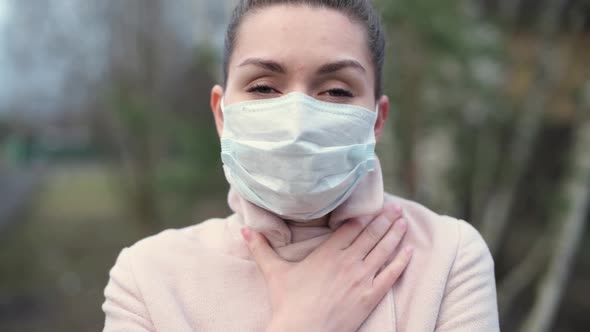 a girl in a medical mask and coat on the street