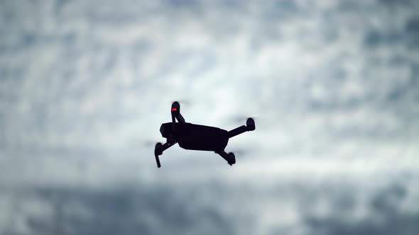 Drone Silhouette Flying on Cloudy Sky