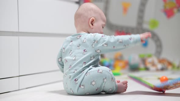 Cute Little Baby Playing with Colorful Toys at Home