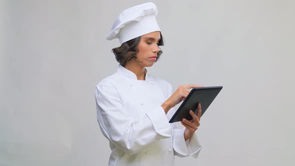 Smiling Female Chef in Toque with Tablet Computer