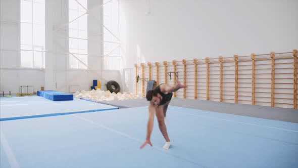 A Male Athlete is Making Four Back Flips Steadicam Front View Slow Motion