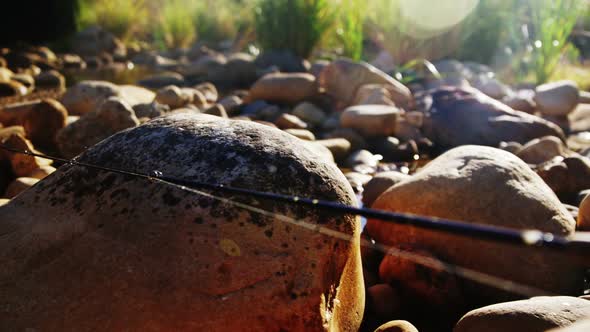 Fly fishing rod, reel and hook on rock