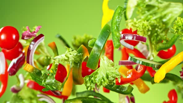 Super Slow Motion Shot of Flying Fresh Vegetables on Green Gradient Background at 1000Fps