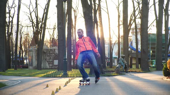 Training of a Professional Roller Who Skillfully Skates in the Central Park of the City and Performs