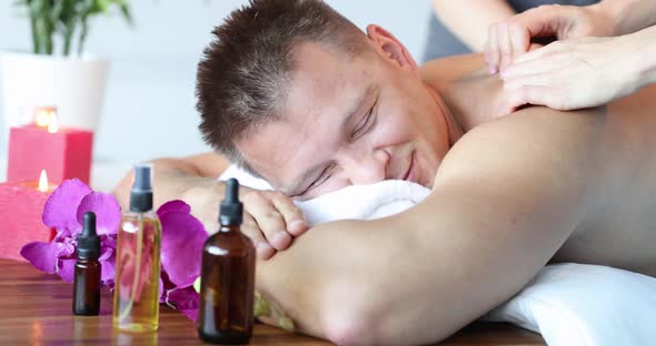 Pleased Relaxed Man Getting Massage in Spa