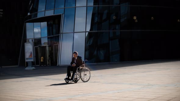 Sad Handsome Entrepreneur Man in Wheelchair Whith Indifferent Crowd