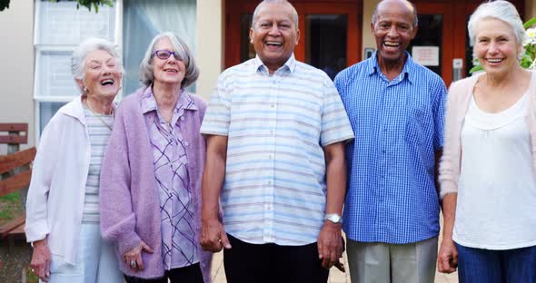 Happy senior friends standing together in lawn 4k