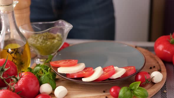 Making Caprese Salad  Putting Sliced Tomatoes and Mozzarella on a Plate