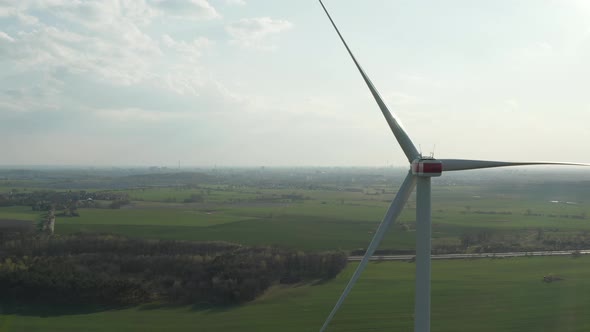 AERIAL: Close Up Shot of Wind Mill Rotating By the Force of the Wind and Generating Renewable Energy