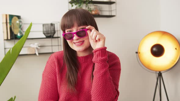 Young Attractive Woman Holding Her Pink Sunglasses Posing and Smiling