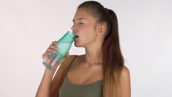 Gorgeous Woman Enjoying Drinking Water From a Bottle, Isolated