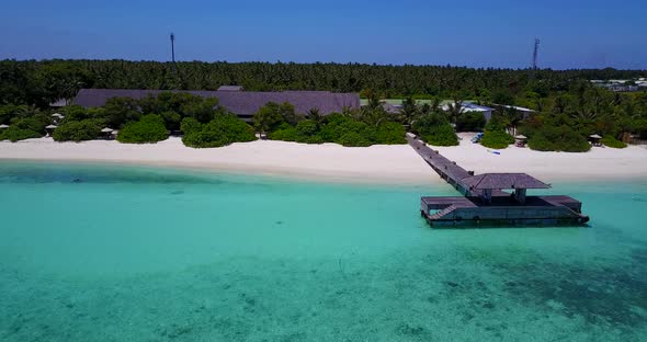 Wide drone travel shot of a sandy white paradise beach and blue ocean background in 4K