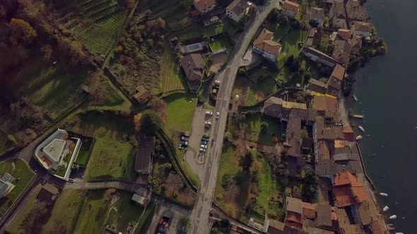 Two Cars Drive Through a European Village Sunny Aerial Shot Switzerland