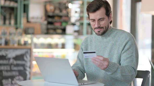 Young Man Excited By Successful Online Shopping Laptop