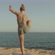Blond Young Caucasian Female Practice Yoga on a Rock Near the Sea - VideoHive Item for Sale